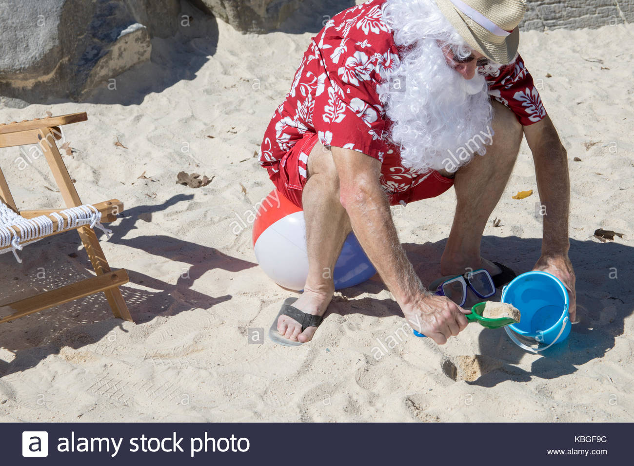 santa-claus-in-red-swimming-trunks-ans-hawaiian-shirt-lounging-on-KBGF9C.jpg